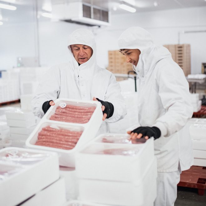 Service logistique de notre activité de boucherie Maître Jacques. Deux personnes vérifient les données sur un colis de chipolatas prêtes à être envoyées au client. Service logistique de notre activité de boucherie Maître Jacques. Deux personnes vérifient les données sur un colis de chipolatas prêtes à être envoyées au client.